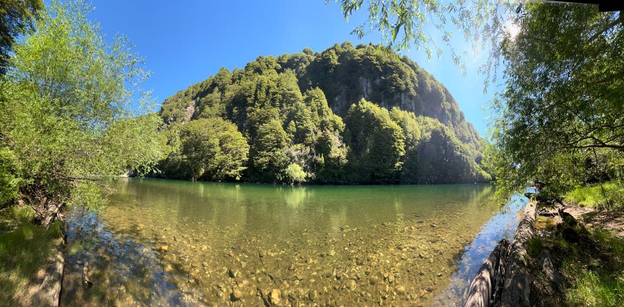 Río de aguas transparentes bajo un cerro con bosque nativo, Río Cisnes